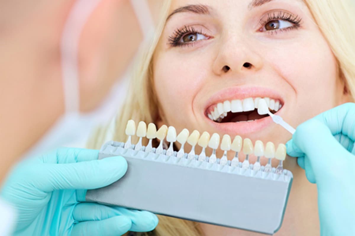 Dr. Sheena Gaur placing a porcelain veneer on a patient