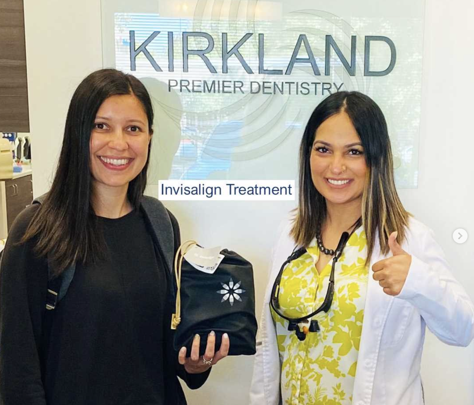 Patient with Invisalign case in front of Kirkland sign